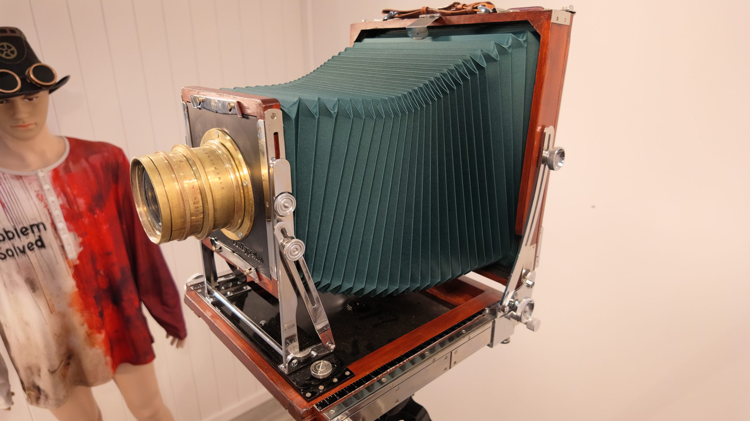 Three-quarter view of the restored Tachihara 8×10 with green bellows, polished metal fittings and a brass lens.