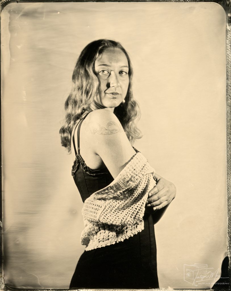 Wetplate maternity portrait of a woman draped in patterned fabric.