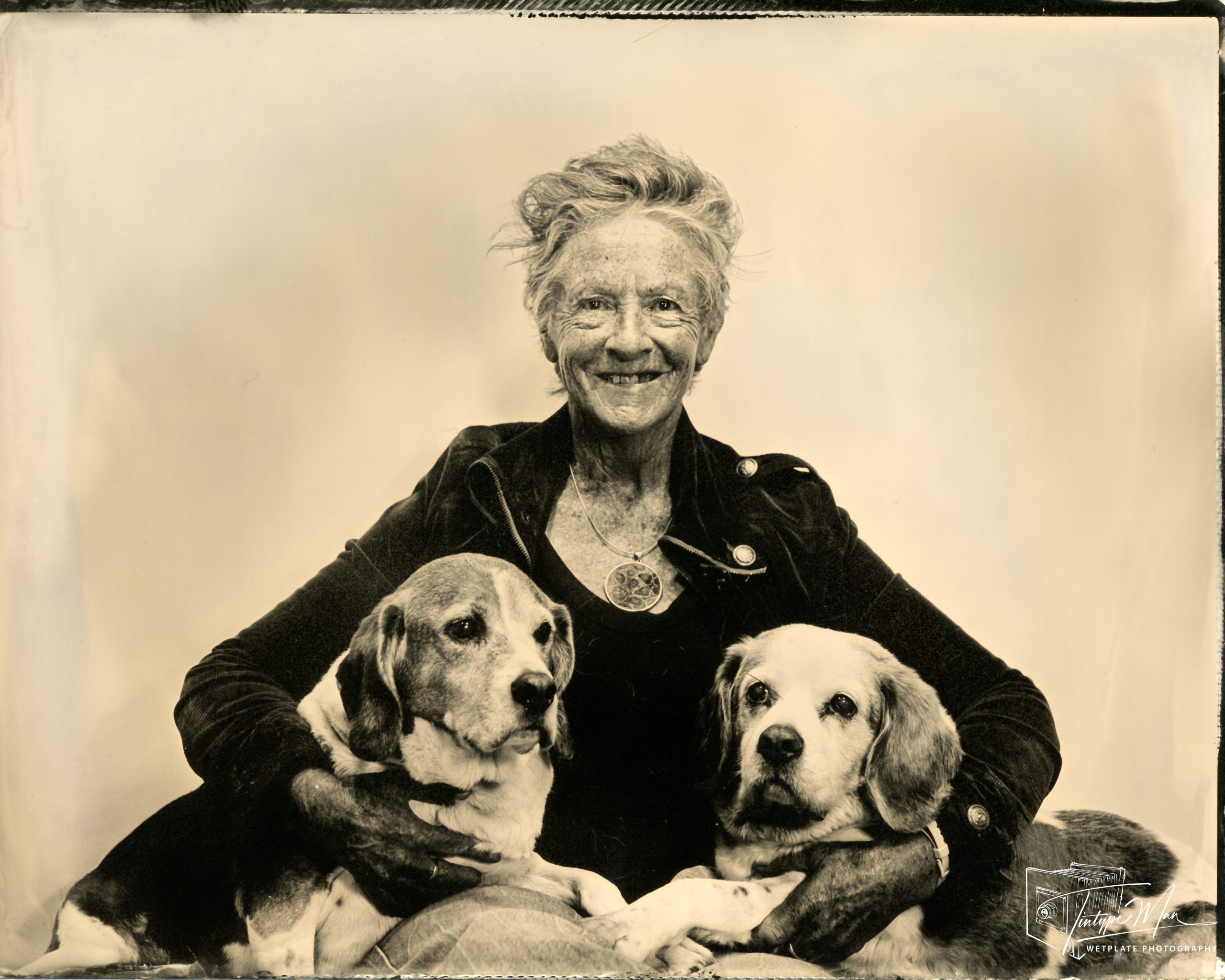 Wetplate portrait of a seated woman with two dogs.